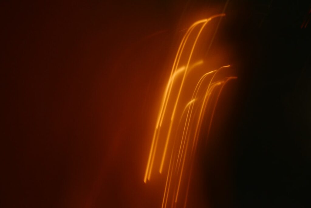 Traînées lumineuses orange sur fond sombre évoquant une intelligence artificielle maîtrisée